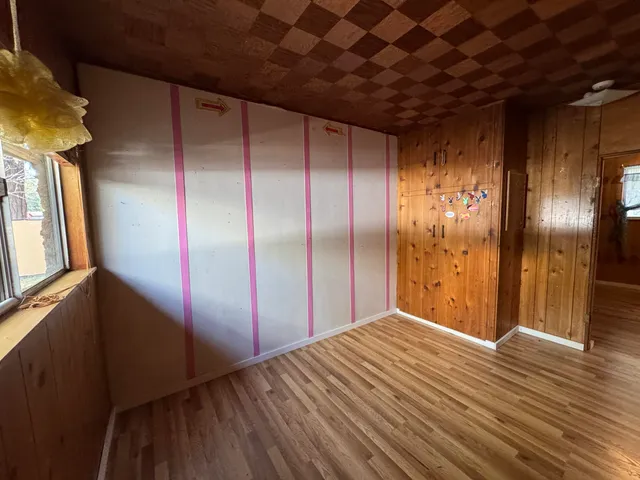 a view of an empty room with closet and a window