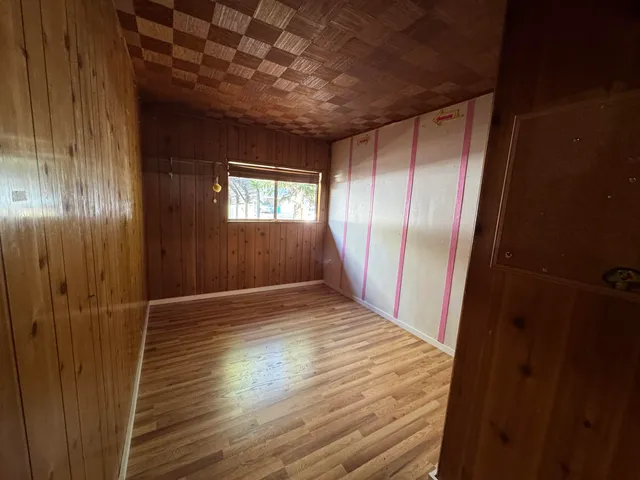 a view of hallway with wooden floor and chandelier
