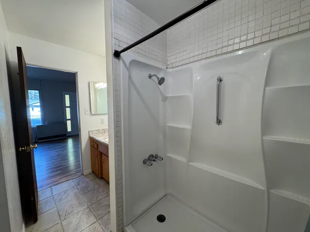 a view of a room with wooden floor and bathroom