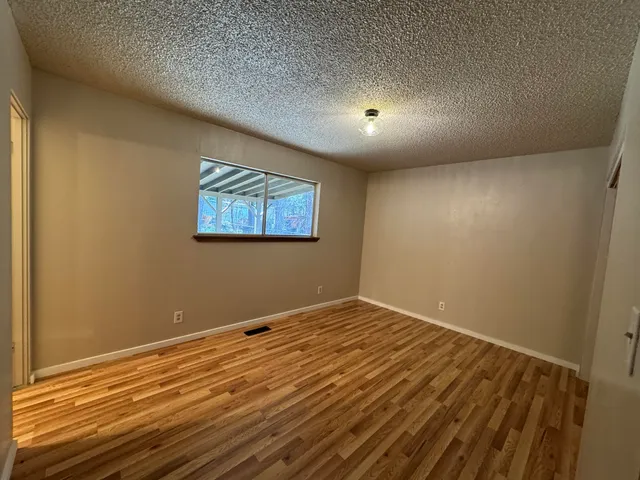 a view of a room with wooden floor and window