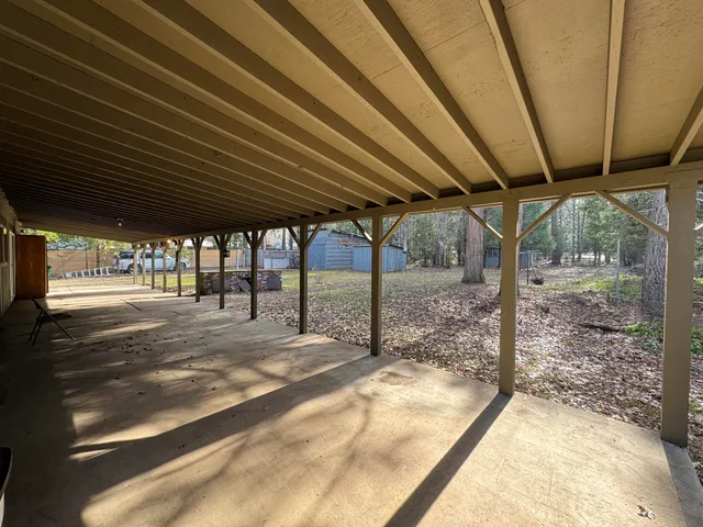 a view of a porch with a bench and wooden fence
