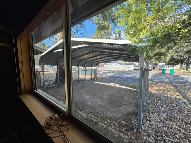 a front view of a house with a yard balcony and tree