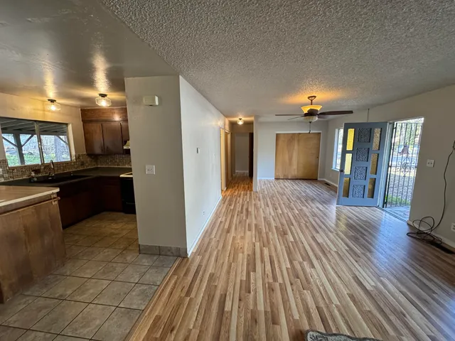 a kitchen with stainless steel appliances granite countertop a sink a stove a refrigerator cabinets and dining table