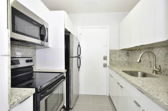 a kitchen with stainless steel appliances granite countertop a sink and a refrigerator