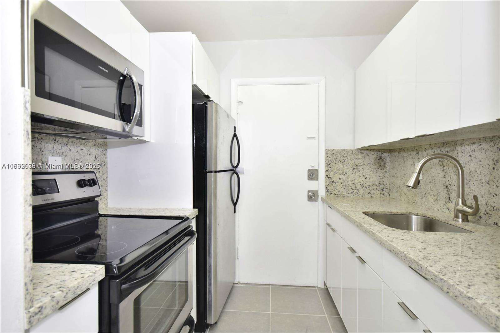 a kitchen with stainless steel appliances granite countertop a sink and a refrigerator