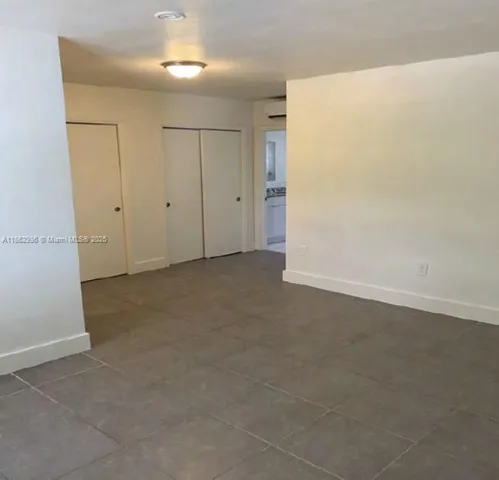 an empty room with closet and windows
