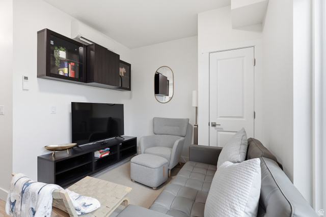 2085 North Main Street, Unit 306 Sunset, UT 84015 - Photo 8 of 18 Living area with white walls and light-colored flooring