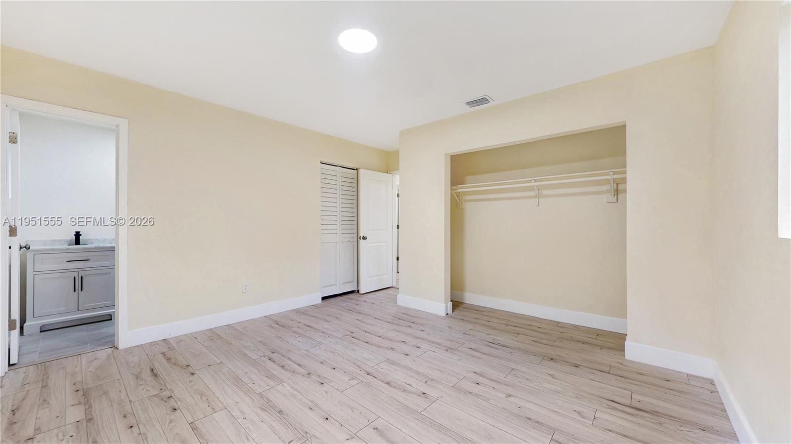 10944 Southwest 159th Terrace Miami, FL 33157 - Photo 12 of 25 wooden floor in an empty room with a window