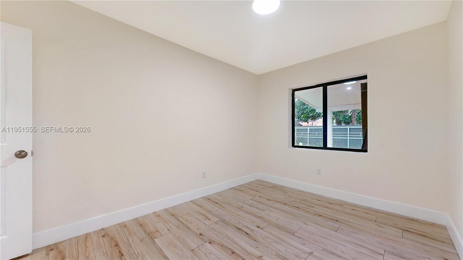 10944 Southwest 159th Terrace Miami, FL 33157 - Photo 16 of 25 an empty room with wooden floor and windows