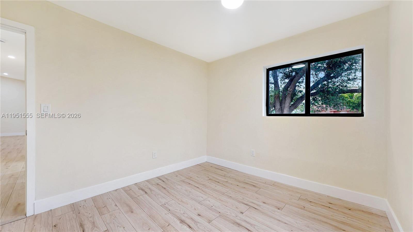 10944 Southwest 159th Terrace Miami, FL 33157 - Photo 18 of 25 an empty room with wooden floor and windows