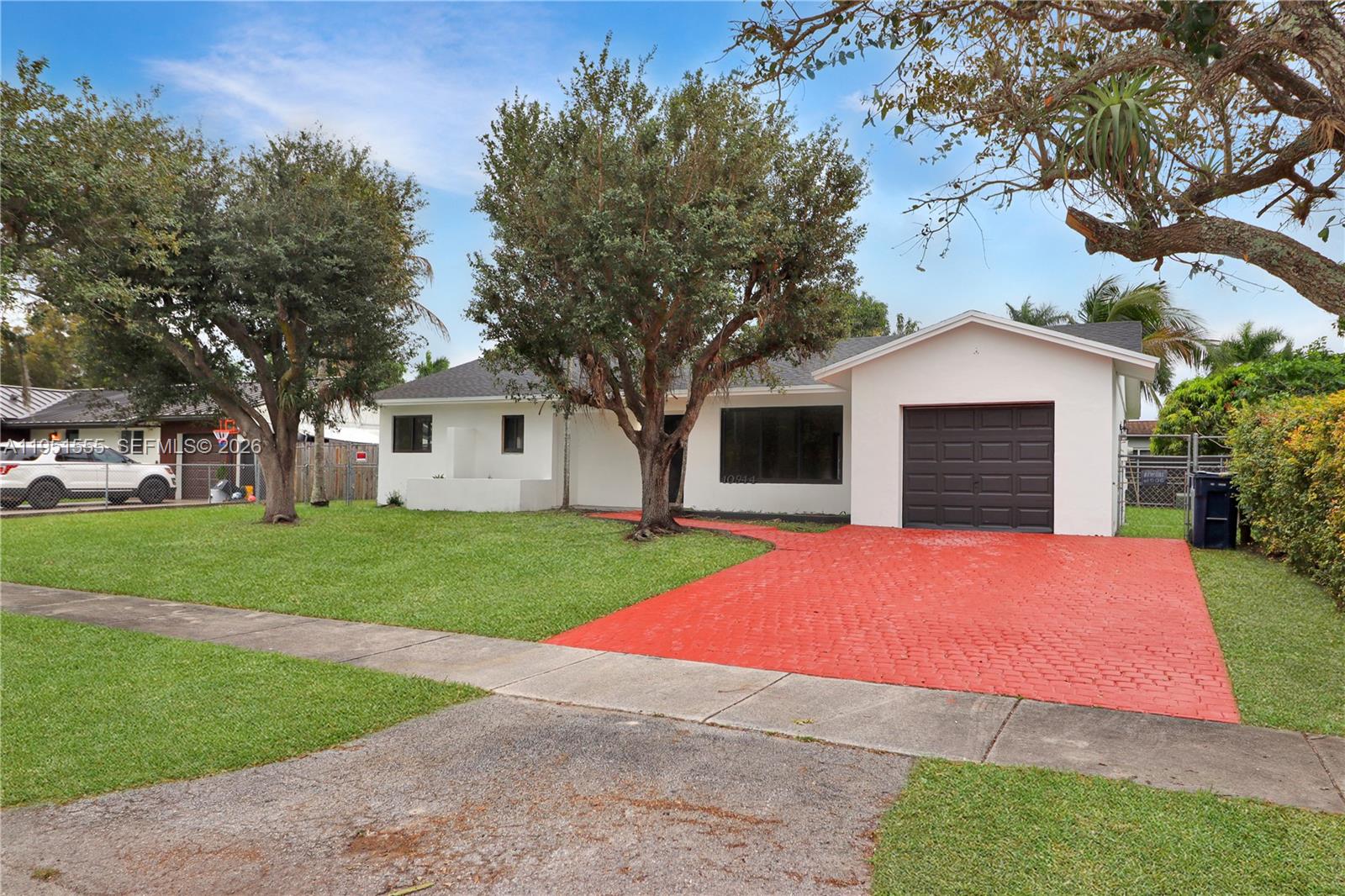 10944 Southwest 159th Terrace Miami, FL 33157 - Photo 25 of 25 a front view of a house with a yard and garage