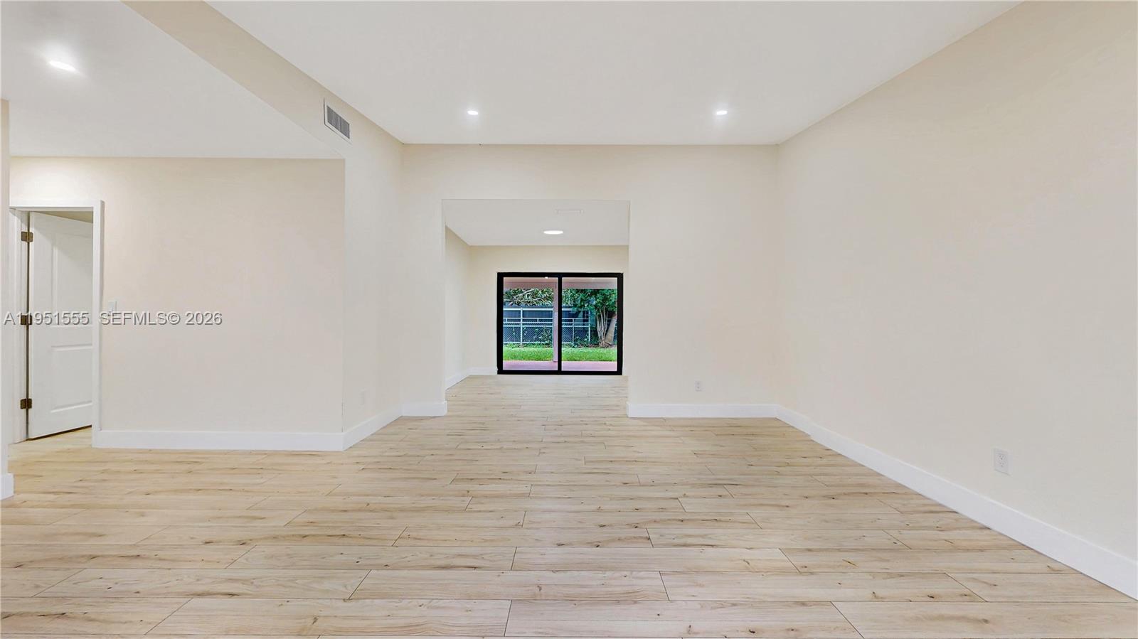 10944 Southwest 159th Terrace Miami, FL 33157 - Photo 6 of 25 a view of an empty room with wooden floor and a window