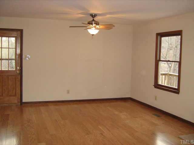 1108 Bahama Road Bahama, NC 27503 - Photo 4 of 10 wooden floor in an empty room with a window