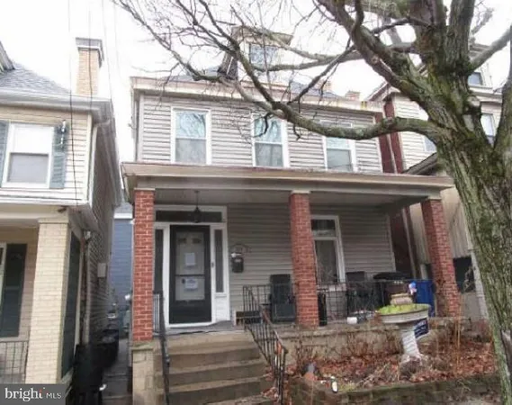 a view of a house with a tree in front