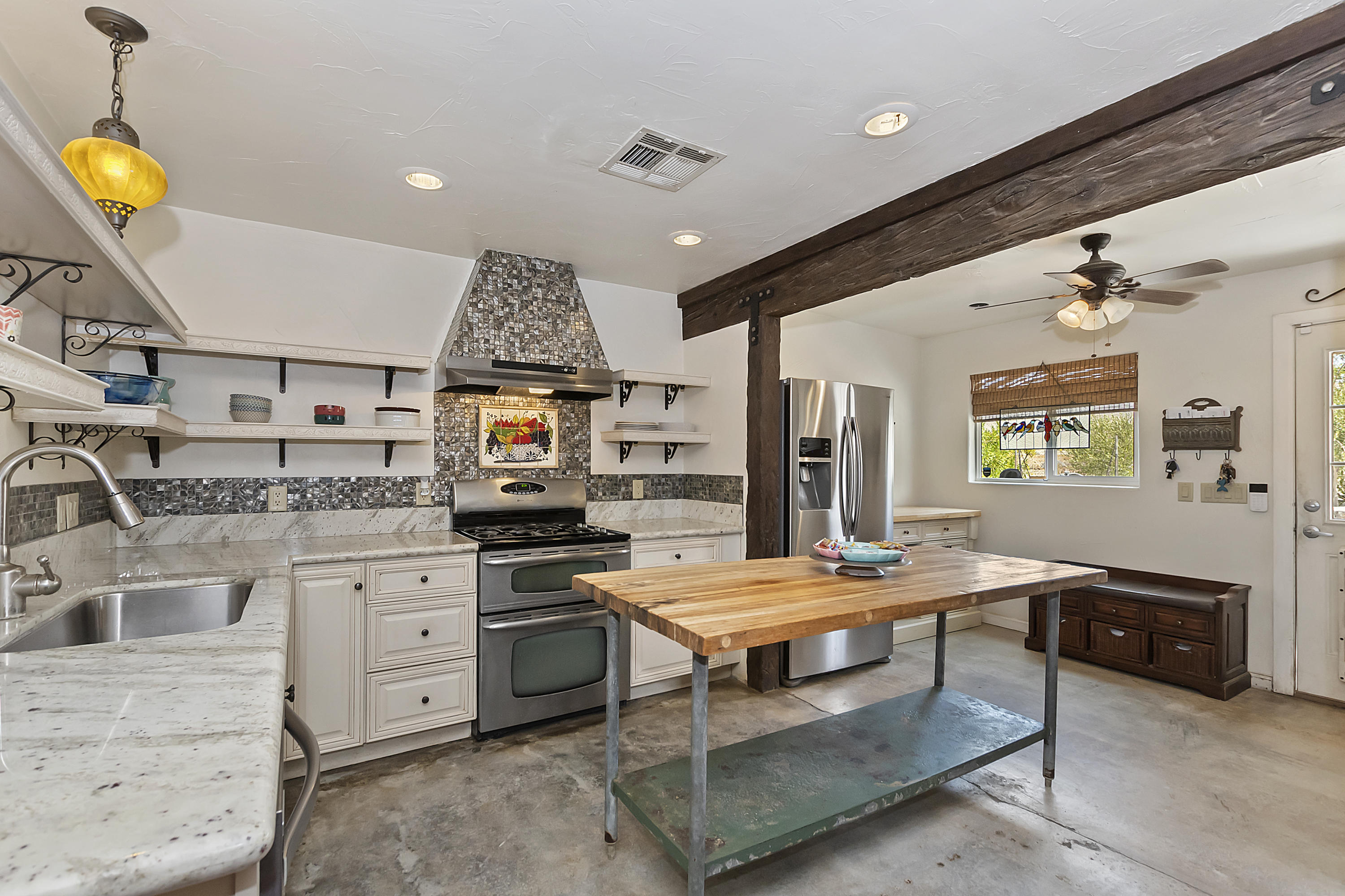 73315 Helms Road Desert Hot Springs, CA 92241 - Photo 16 of 41 a living room with stainless steel appliances kitchen island granite countertop furniture and a kitchen view