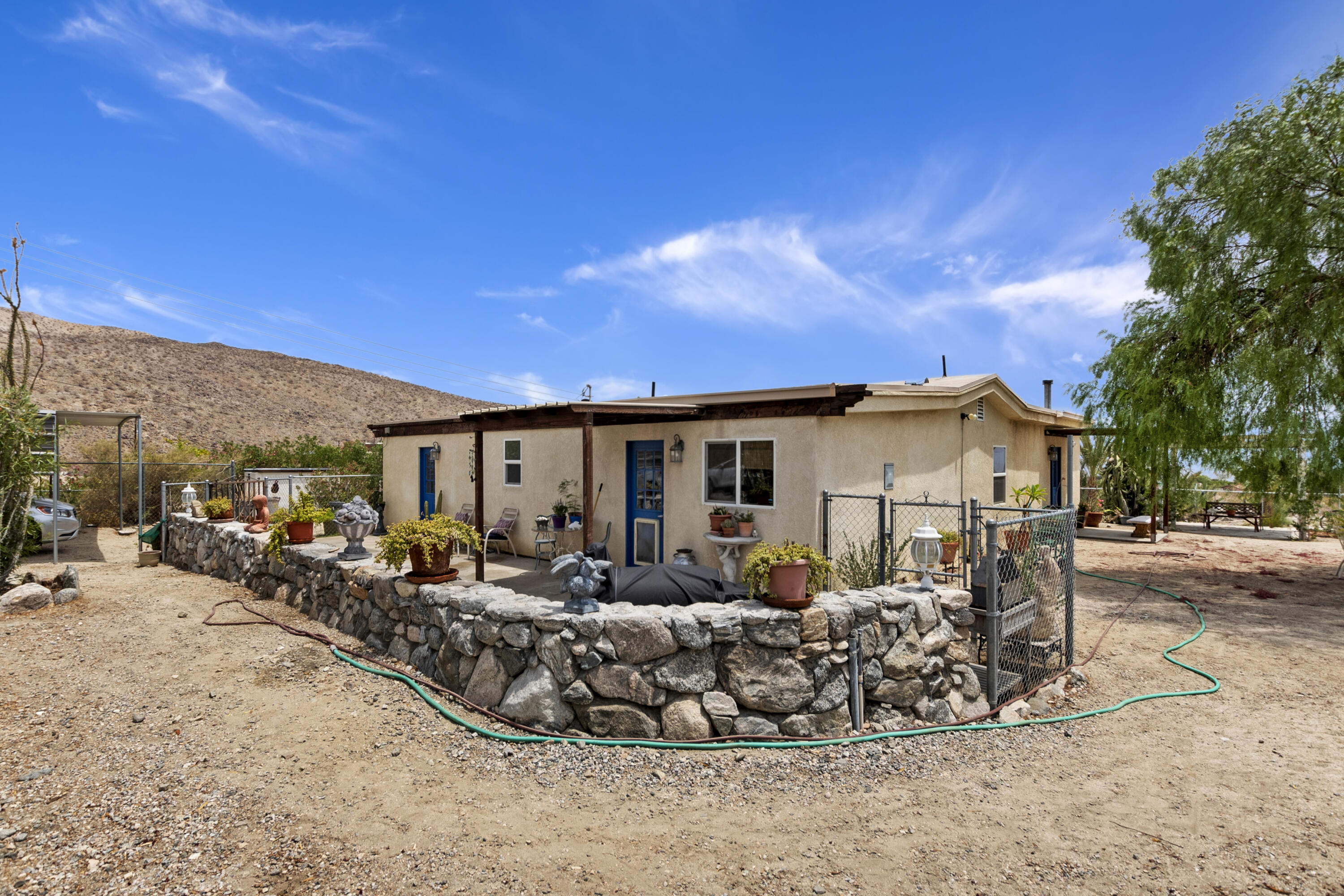 73315 Helms Road Desert Hot Springs, CA 92241 - Photo 4 of 41 a front view of house with yard outdoor seating and barbeque oven