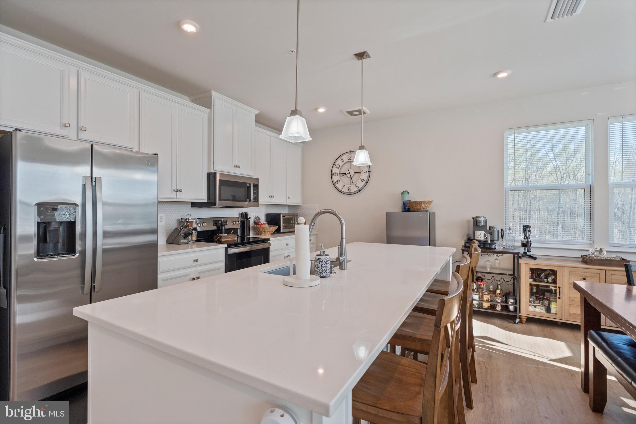 10411 Resort Road, Unit B Ellicott City, MD 21042 - Photo 15 of 36 a kitchen with stainless steel appliances a table chairs and a window