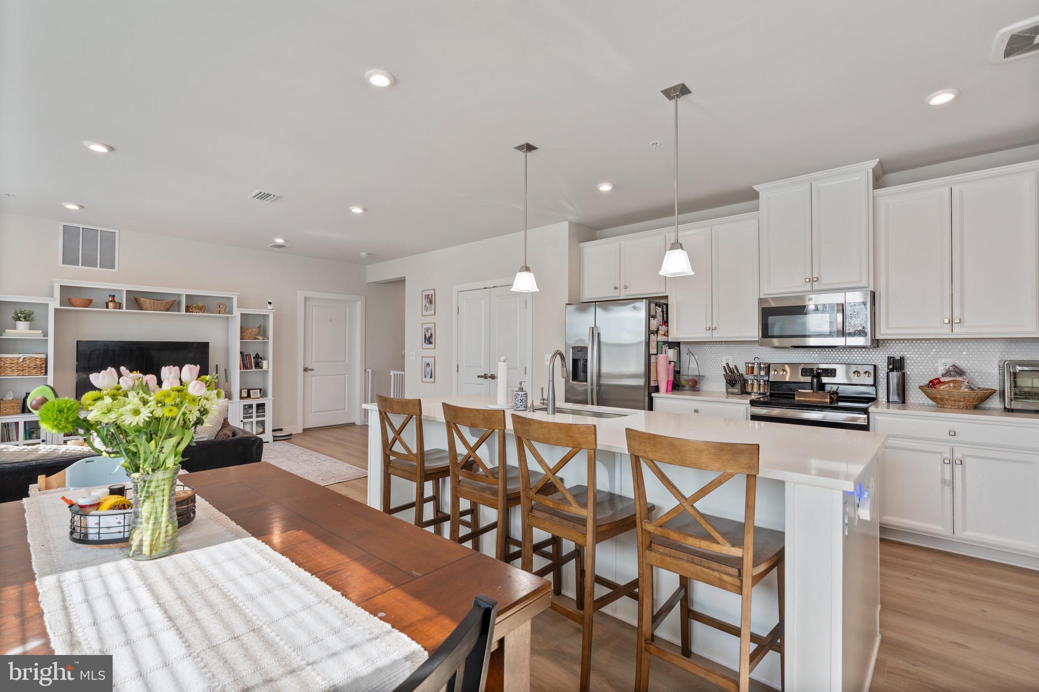 10411 Resort Road, Unit B Ellicott City, MD 21042 - Photo 18 of 36 a kitchen with stainless steel appliances granite countertop a table chairs sink and cabinets