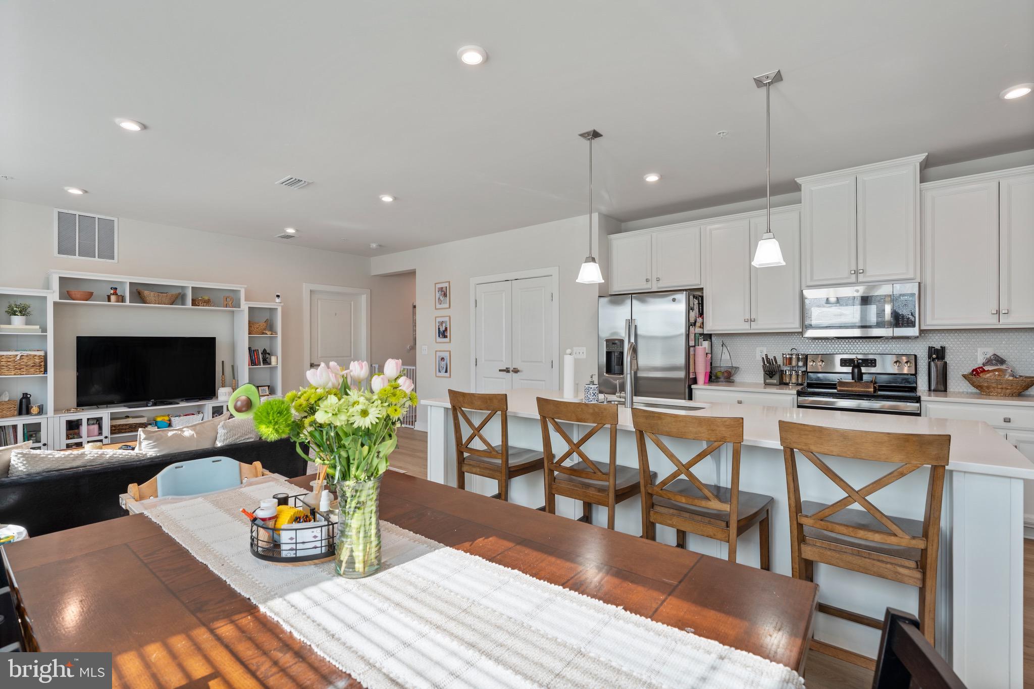10411 Resort Road, Unit B Ellicott City, MD 21042 - Photo 19 of 36 a kitchen with stainless steel appliances kitchen island granite countertop a dining table chairs and white cabinets