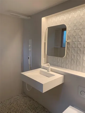 a bathroom with a sink a toilet and mirror