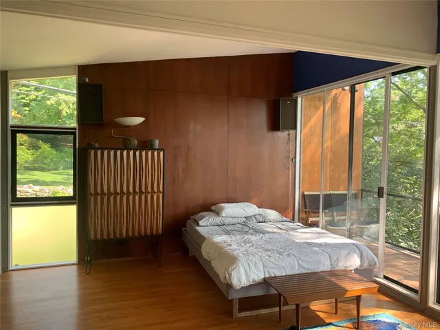 a bedroom with a bed and a large window