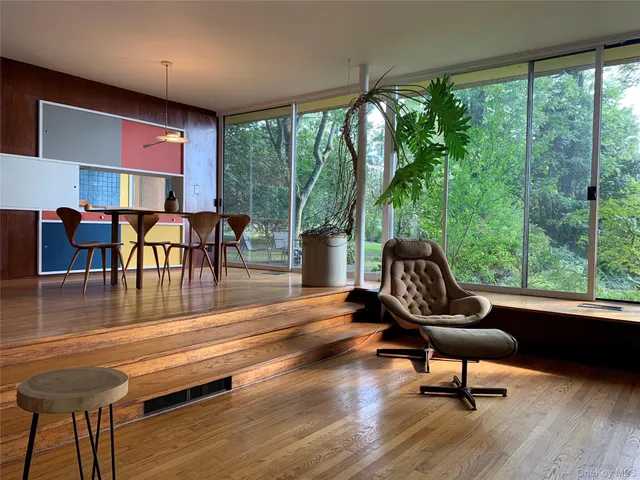 a living room with furniture and floor to ceiling windows