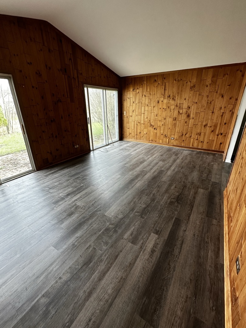 730 Hageman Place Naperville, IL 60563 - Photo 4 of 25 a view of an empty room with wooden floor and a window