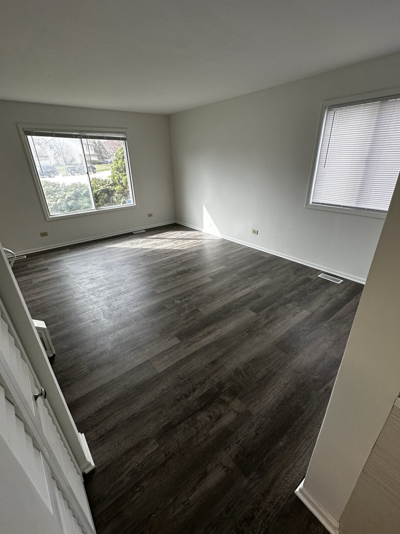 730 Hageman Place Naperville, IL 60563 - Photo 6 of 25 a view of an empty room with wooden floor and a window