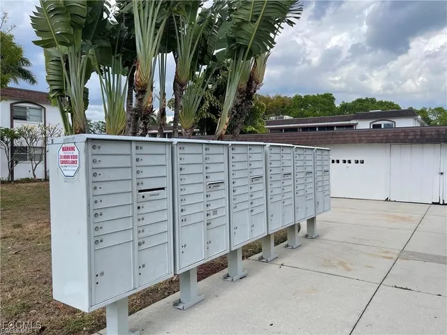 front view of a wooden building with large trees