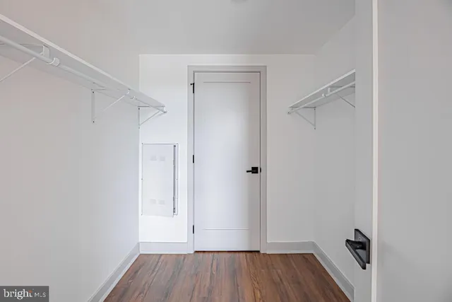 a view of room with walk in closet and wooden floor