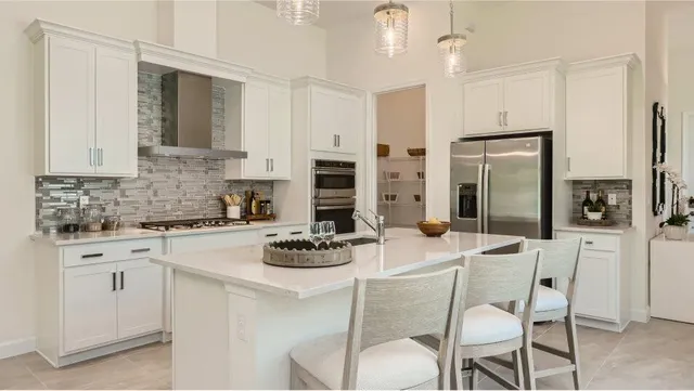 a kitchen with stainless steel appliances a dining table chairs and a refrigerator