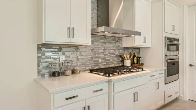 a kitchen with white cabinets and appliances