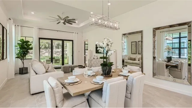 a living room with furniture a chandelier and a dining table