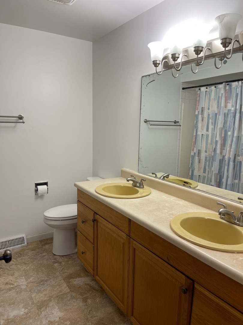 2013 Hickory Street Waukegan, IL 60087 - Photo 11 of 25 a bathroom with a granite countertop sink toilet and mirror