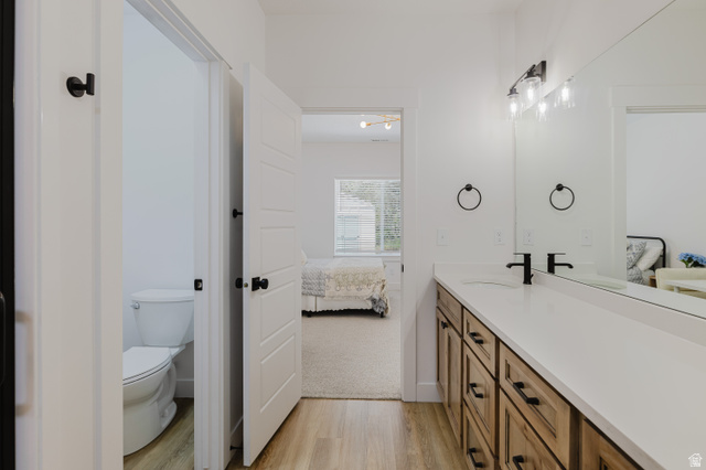 287 East 1000 North Logan, UT 84321 - Photo 24 of 41 Bathroom vanity featuring a light wood-finish cabinet with black hardware, a pristine white countertop, and dual matte black faucets