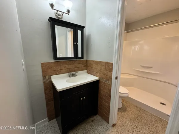 a bathroom with a sink a toilet and shower