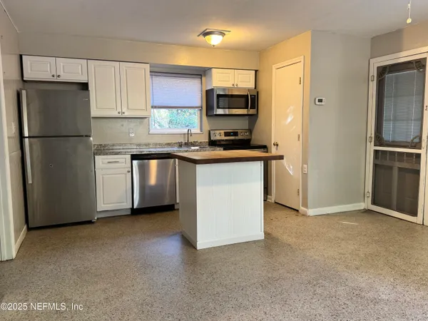 a kitchen with stainless steel appliances a refrigerator stove microwave and sink