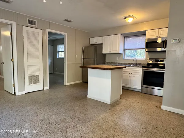 a kitchen with stainless steel appliances granite countertop a refrigerator stove and sink