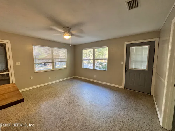 an empty room with windows and closet