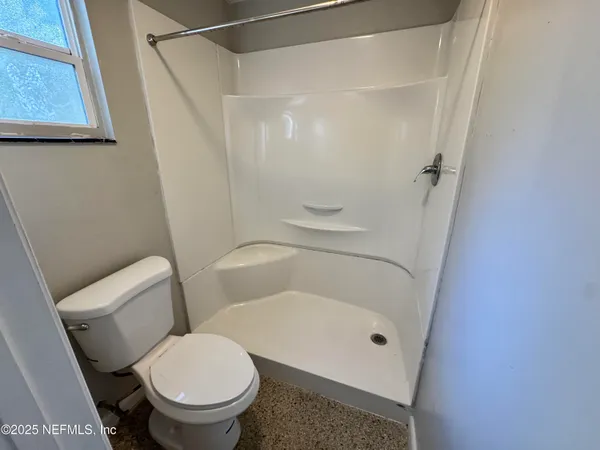 a white toilet sitting next to a shower