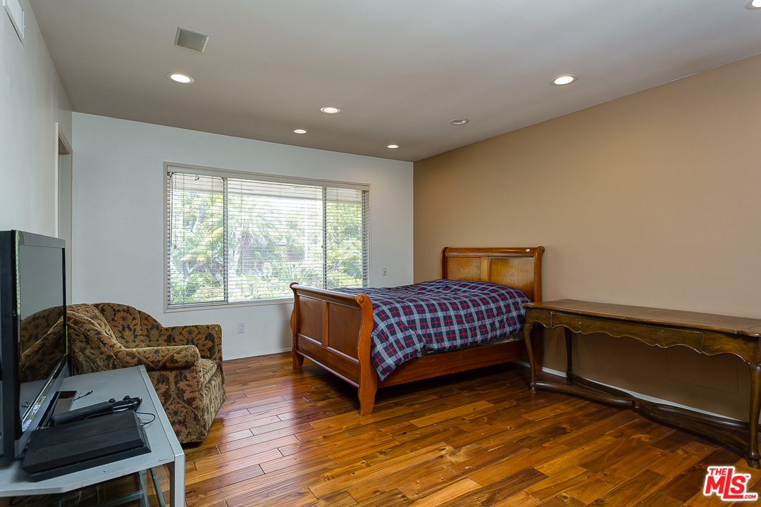 1040 Maybrook Drive Beverly Hills, CA 90210 - Photo 23 of 31 a bedroom with a bed and wooden floor