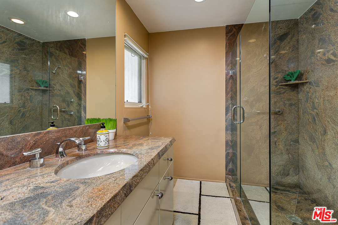 1040 Maybrook Drive Beverly Hills, CA 90210 - Photo 26 of 31 a bathroom with a granite countertop sink a mirror and shower