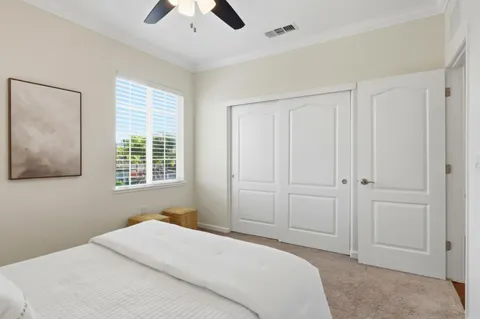 a spacious bedroom with a bed lamp and a rug