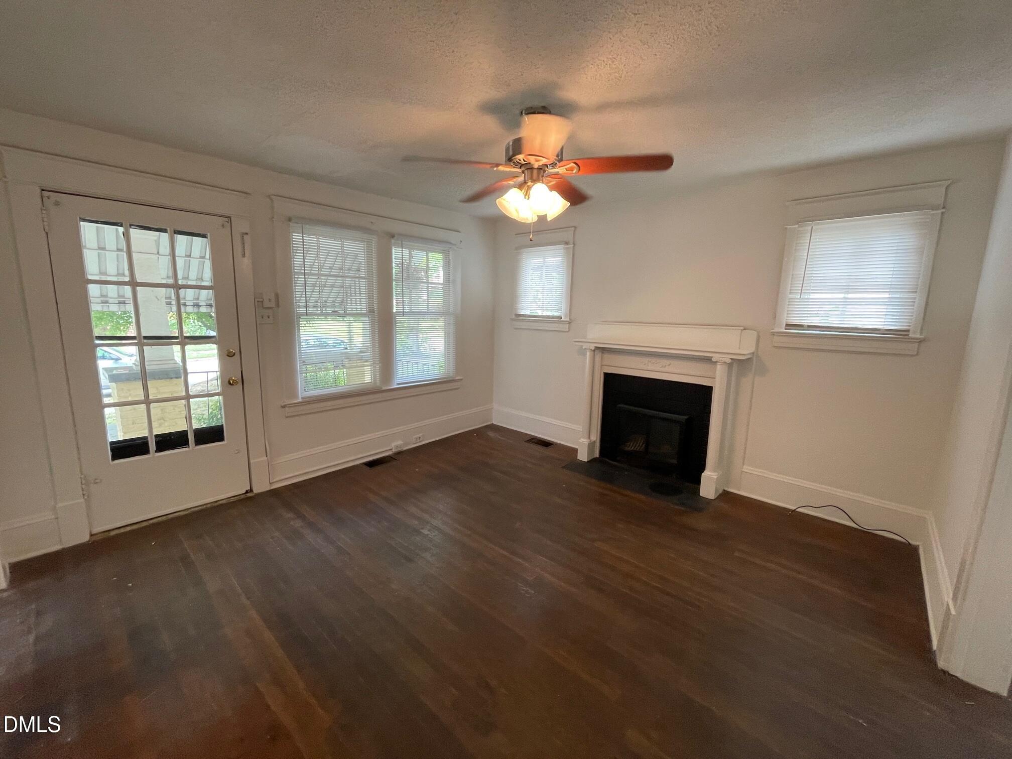 404 Chamberlain Street, Unit A Raleigh, NC 27607 - Photo 3 of 12 an empty room with wooden floor fan and windows