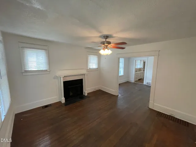 a view of a livingroom with a fireplace wooden floor and a chandelier