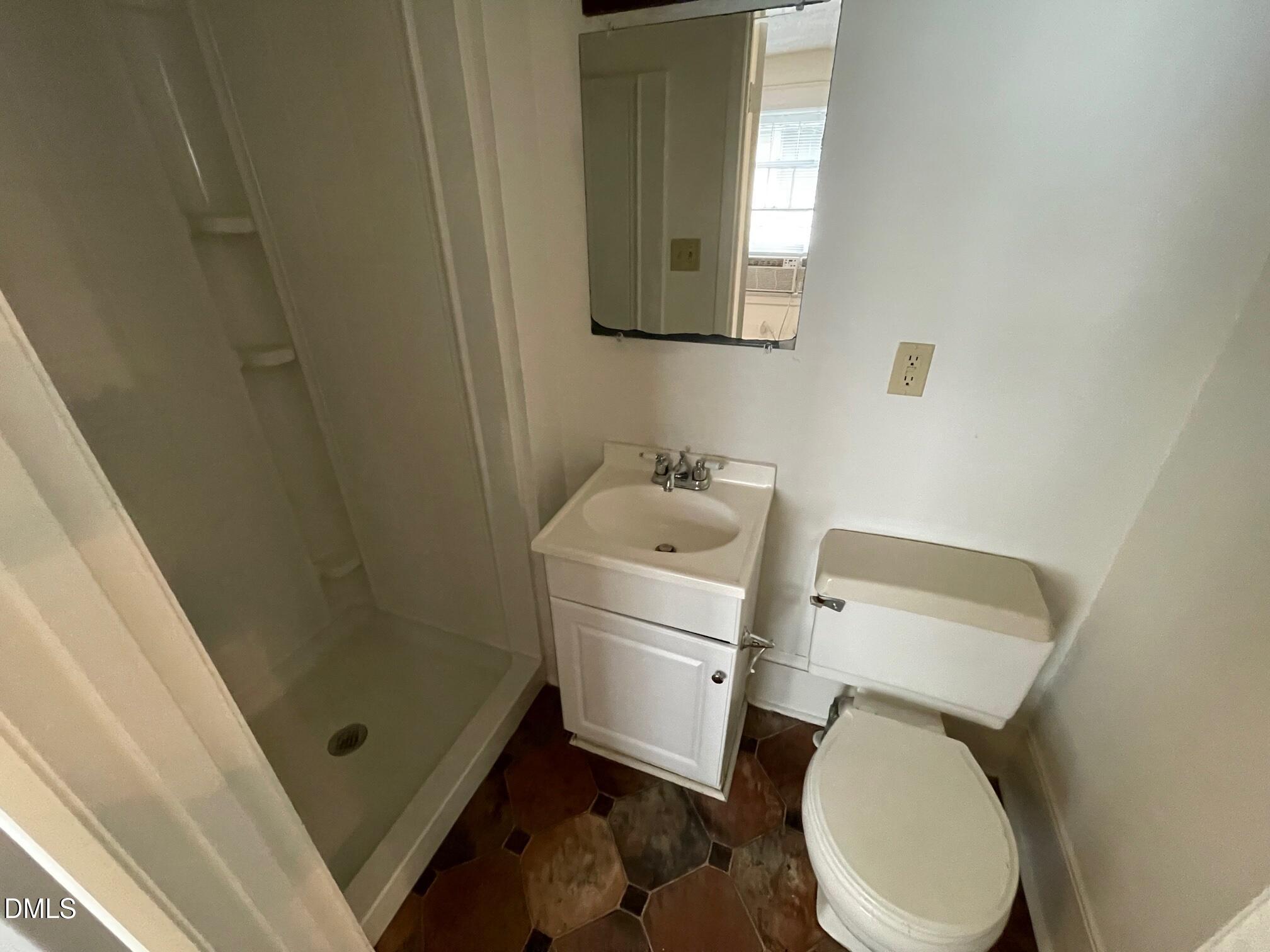 404 Chamberlain Street, Unit A Raleigh, NC 27607 - Photo 10 of 12 a bathroom with a sink a toilet and a mirror