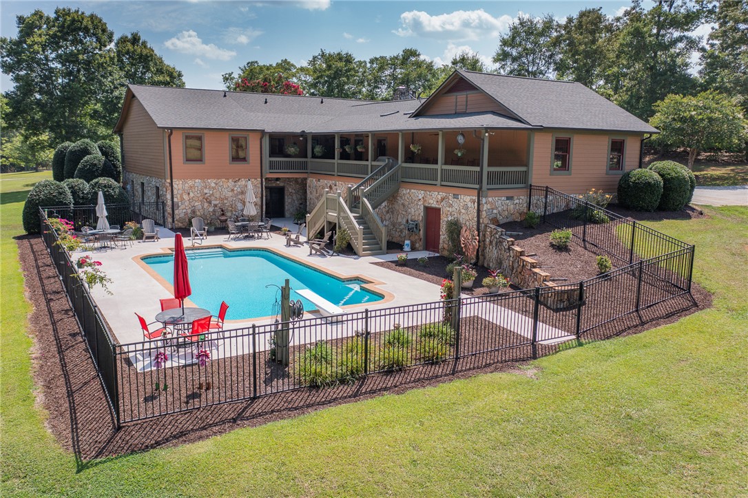 911 State Rd S-4-203 Belton, SC 29627 - Photo 3 of 49 An inviting backyard oasis offers a sparkling in-ground pool, expansive patio, and generous outdoor entertaining areas.