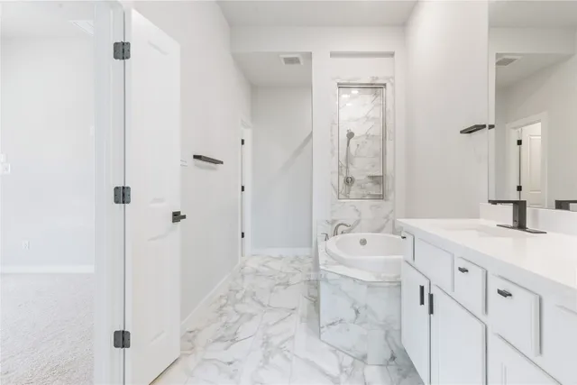 a spacious bathroom with a tub sink shower and mirror