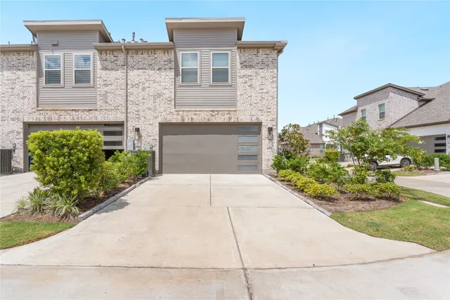 a front view of a house with a yard and potted plants