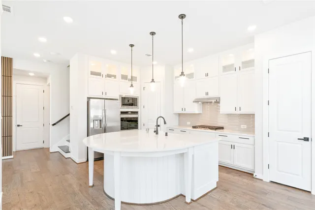 a kitchen with kitchen island a sink stainless steel appliances and cabinets